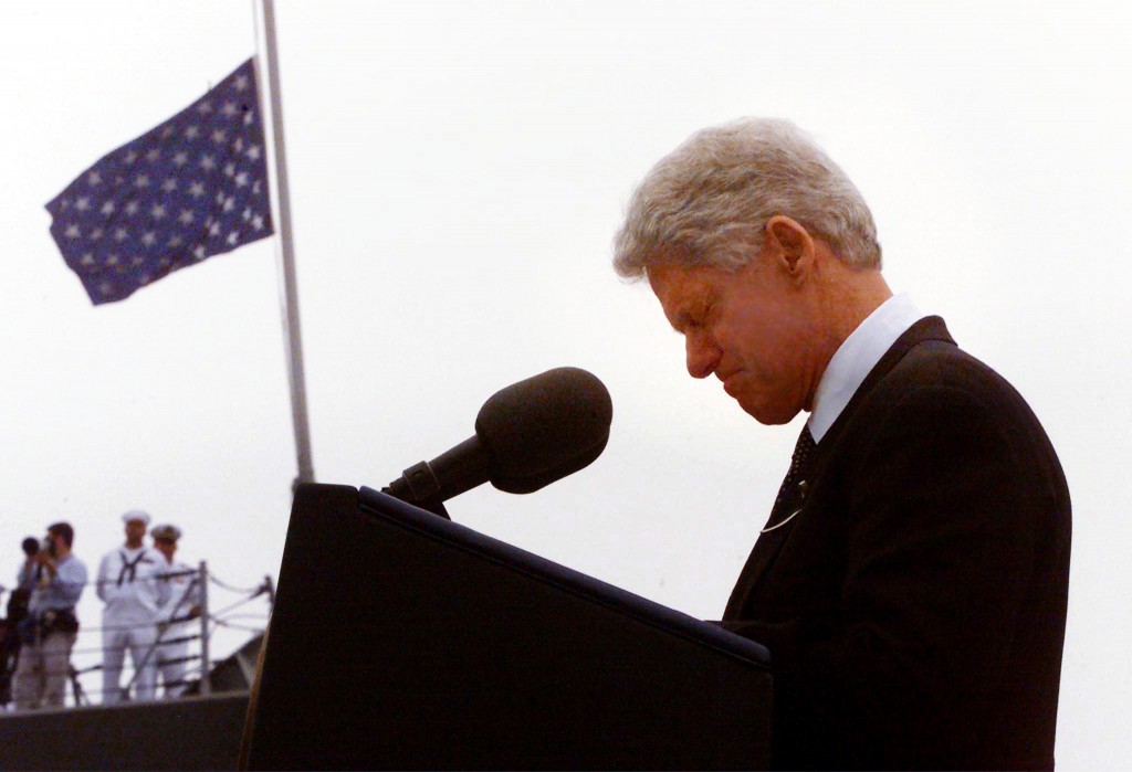 President Bill Clinton bows his head in a moment of silence during a memorial service for victims of the explosion on the USS Cole, 18 October, 2000. The attack in Yemen left 17 US sailors dead and 39 injured. (Credit: Mario Tama/AFP/Getty Images)