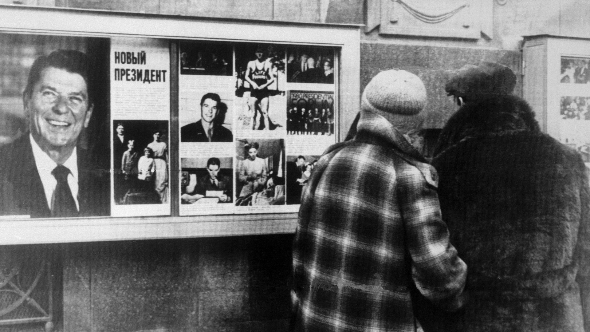 Muscovites stop and glance at a display of photographs of President-Elect Ronald Reagan on outside wall of the U.S. Embassy. (credit: Bettmann/Getty Images)