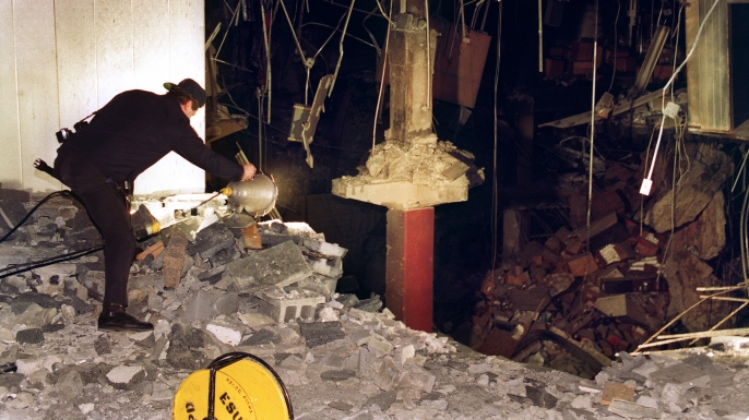 A police photographer examines damage to an underground paring garage following the 1993 World Trade Center bombing.