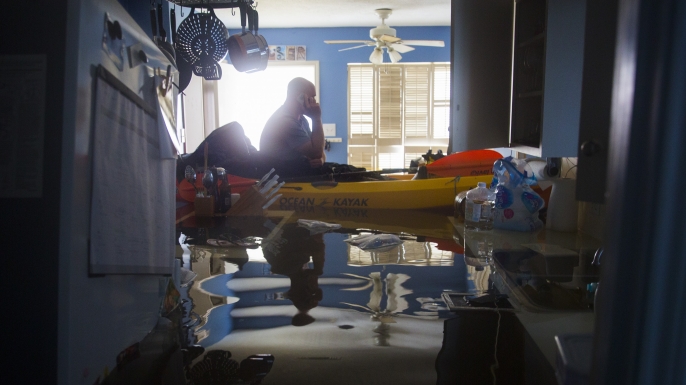 Larry Koser Jr., calling his wife looking for important papers and heirlooms inside his father's house after it was flooded by Hurricane Harvey. (Credit: Erich Schlegel/Getty Images)