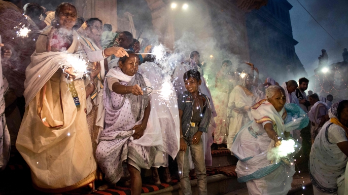 Indian women wave sparklers as they participate in a celebration for the Hindu festival Diwali on the banks of the Yamuna river in the northern city of Vrindavan, 2014. (Credit: Roberto Schmidt/AFP/Getty Images)