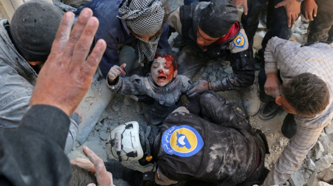 The White Helmets rescue a boy from the rubble following a reported barrel bomb attack on the Bab al-Nairab neighborhood of the northern Syrian city of Aleppo on November 24, 2016. (Credit: AMEER ALHALBI/AFP/Getty Images)