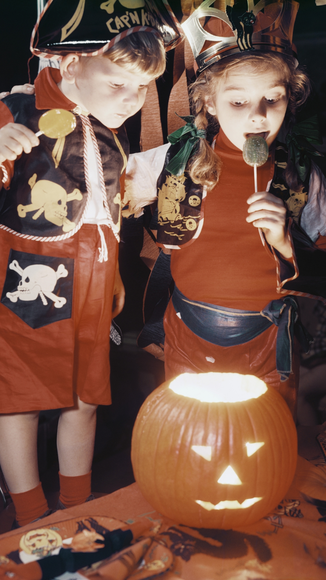 Children looking into glowing jack-o-lantern