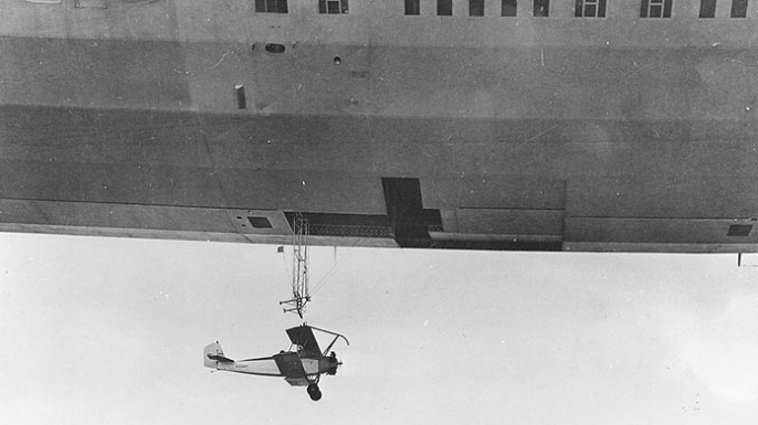 USS Akron launching a Consolidated N2Y-1 training plane during flight tests near Naval Air Station Lakehurst, New Jersey, 1932. (Credit: U.S. Navy Naval History and Heritage Command)