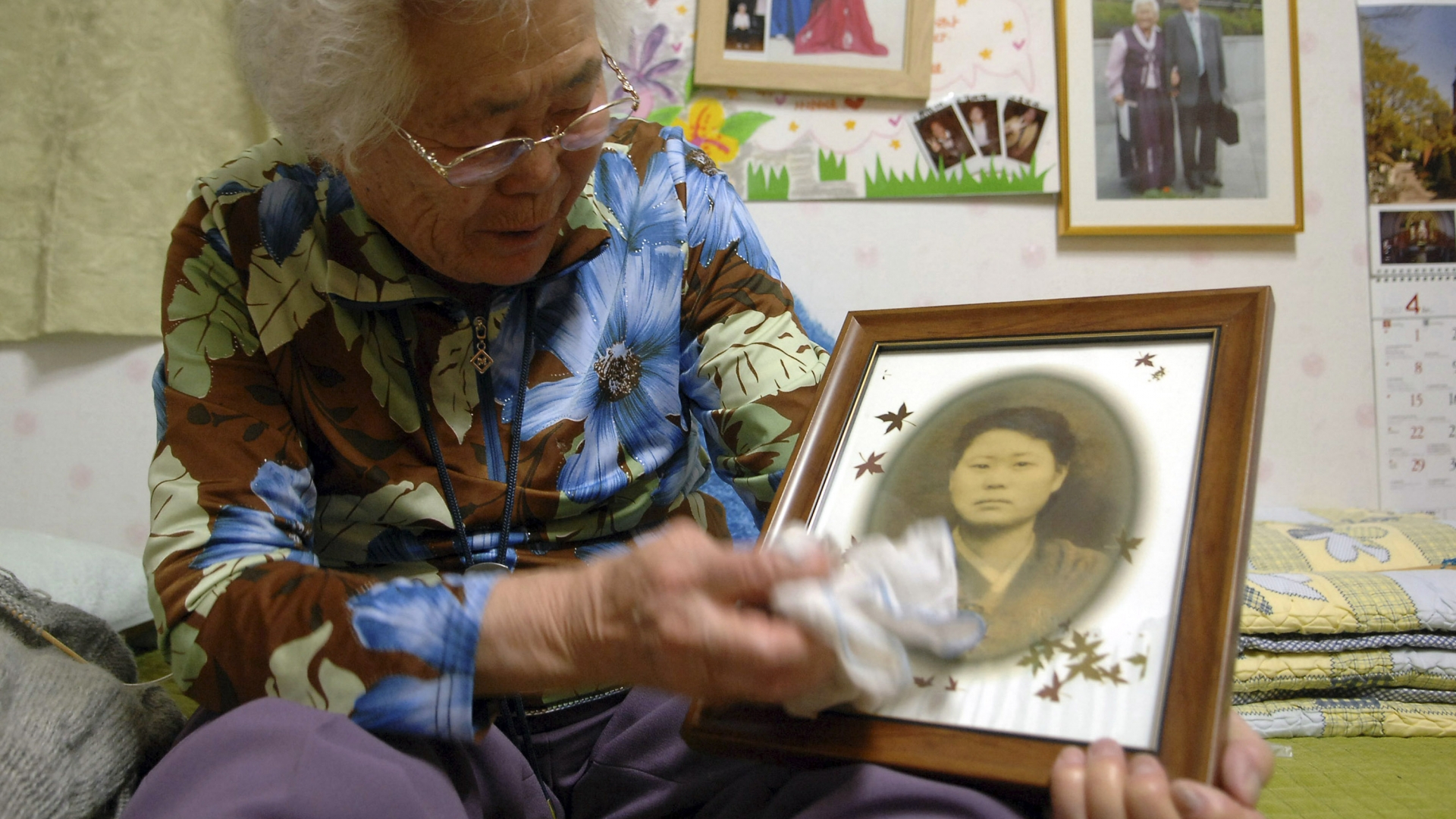 Lee Ok-seon, then 80, in a shelter for former sex slaves near Seoul, South Korea, holding an old photo of herself on April 15, 2007. (Credit: Seokyong Lee/The New York Times/Redux)