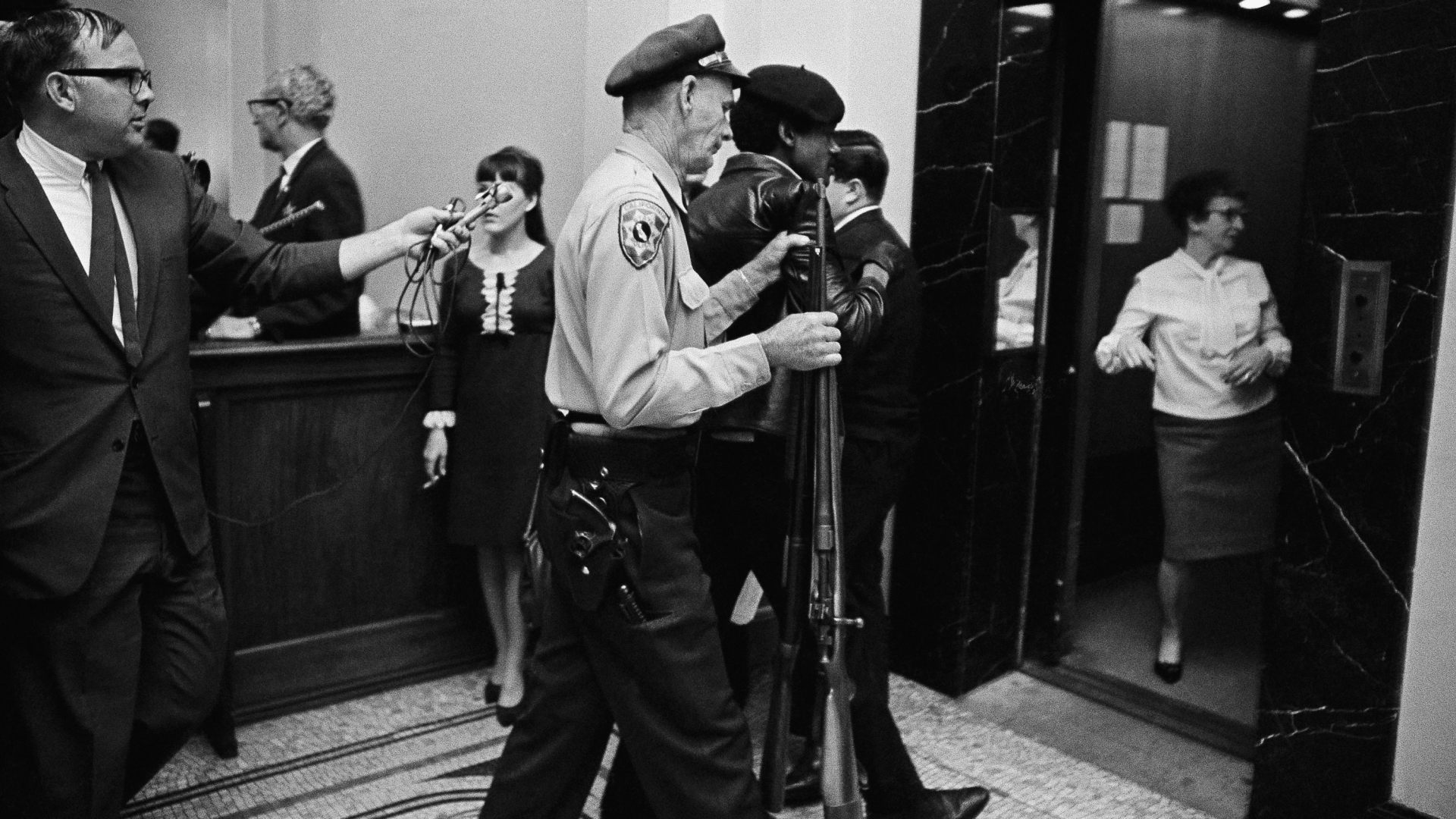 A California State Policeman escorting a member of the Black Panther Party down the corridor of the Capitol in Sacramento, 1967. (Credit: AP Photo )