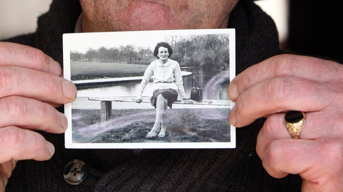 John Pascal Rodgers, who was born in Tuam, Ireland, at a home for unmarried mothers run by nuns, poses with a photograph of his mother Bridie Rodgers. (Credit: Paul FaithAFP/Getty Images)