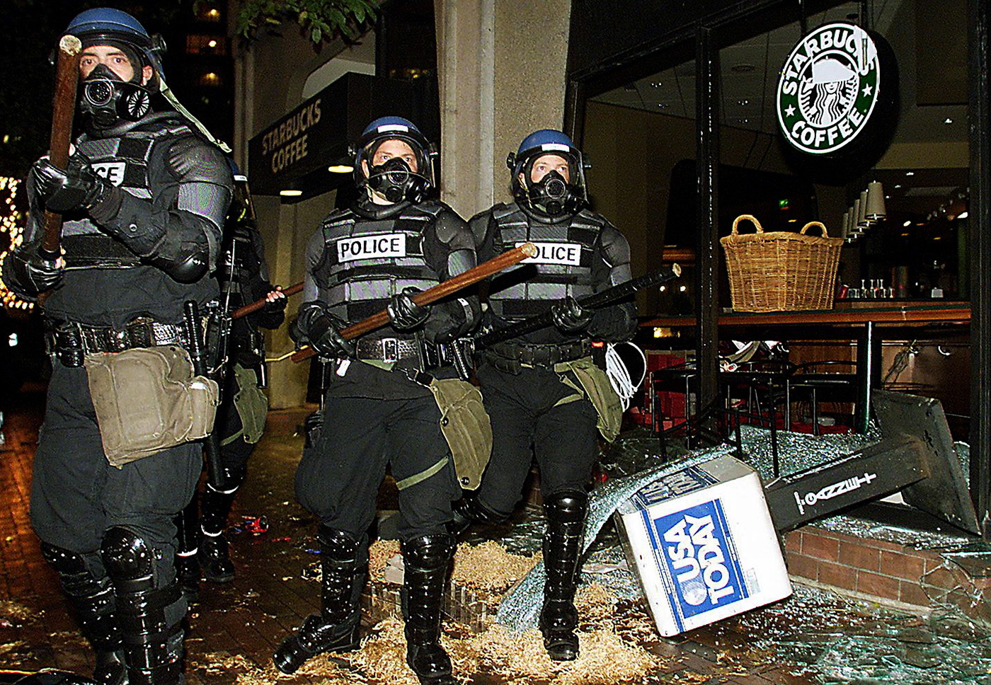 Seattle riot police marching past a damaged Starbucks during demonstrations against the World Trade Organization, 1999. (Credit: Mike Nelson/AFP/Getty Images)