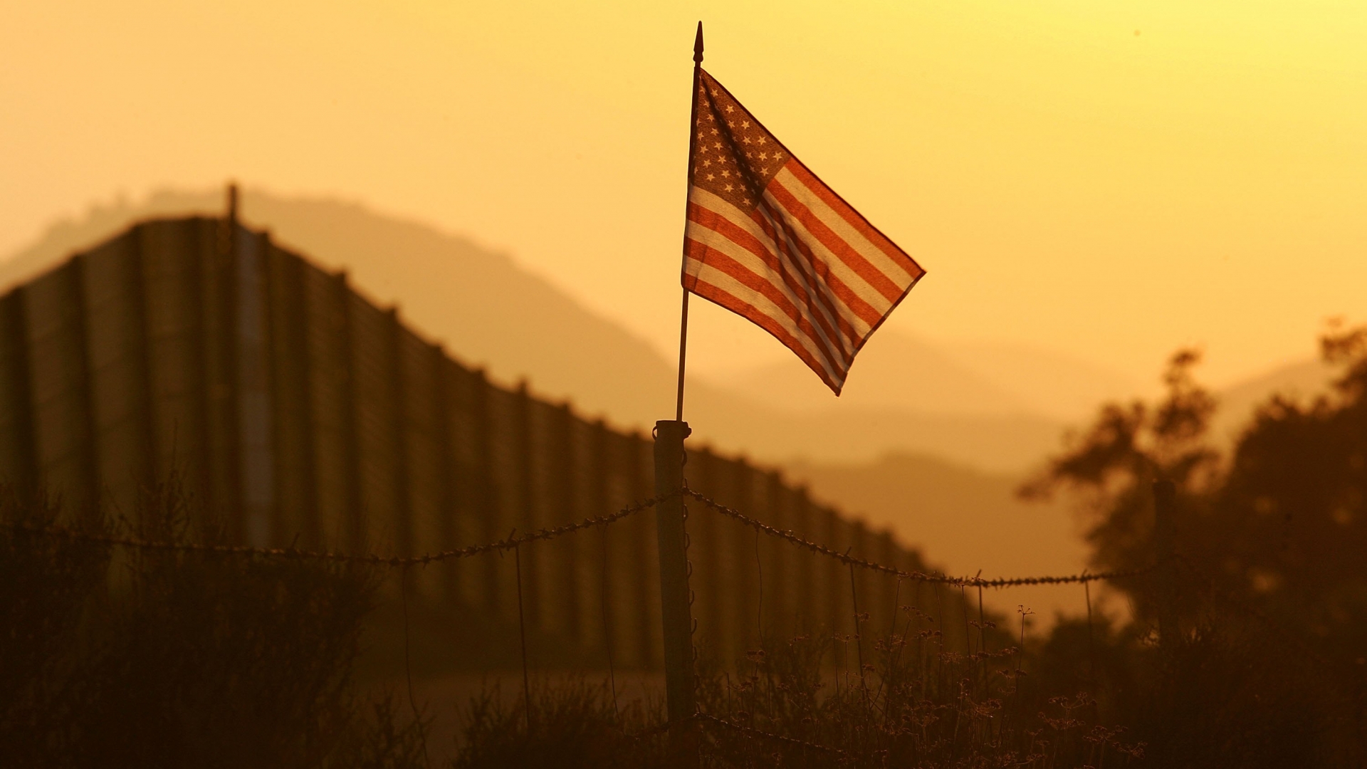 A U.S. flag, put up by activists who oppose illegal immigration, near the US-Mexico border fence in an area where they search for border crossers near Campo, California, 2006. (Credit: David McNew/Getty Images)