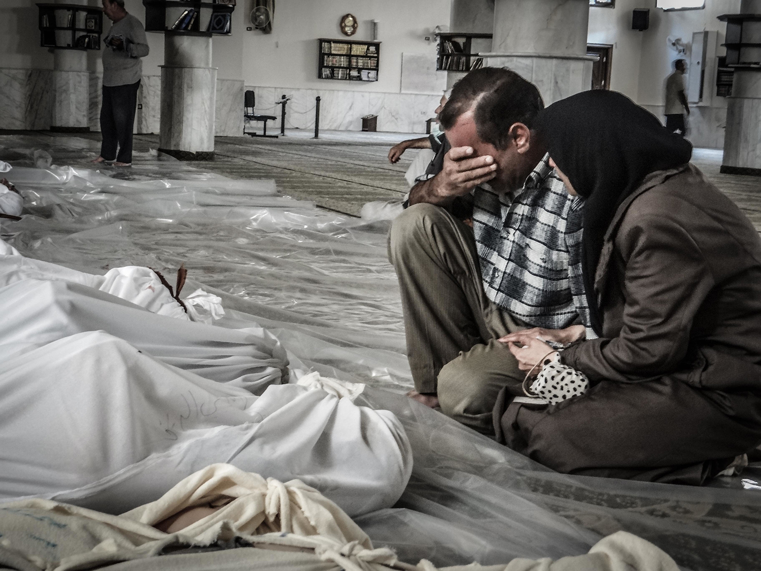 A mother and father weep over their child's body who was killed in a suspected chemical weapons attack on the Damascus suburb of Ghouta, in August 21, 2013. (Credit: NurPhoto/Corbis/Getty Images)