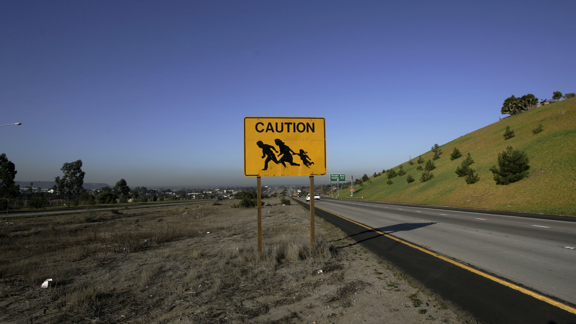 A sign is posted near the US and Mexico border warning drivers of immigrants crossing the freeway in San Ysidro, CA in 2006, just before the signing of the Secure Fence Act. (Credit: Hector Mata/AFP/Getty Images)